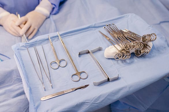 pexels-photo-28727569-28727569 A set of surgical instruments carefully arranged on a blue drape during an operation.